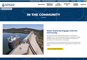 A group of people stands on a dam overlooking a reservoir on the San Diego County Water Authority's 