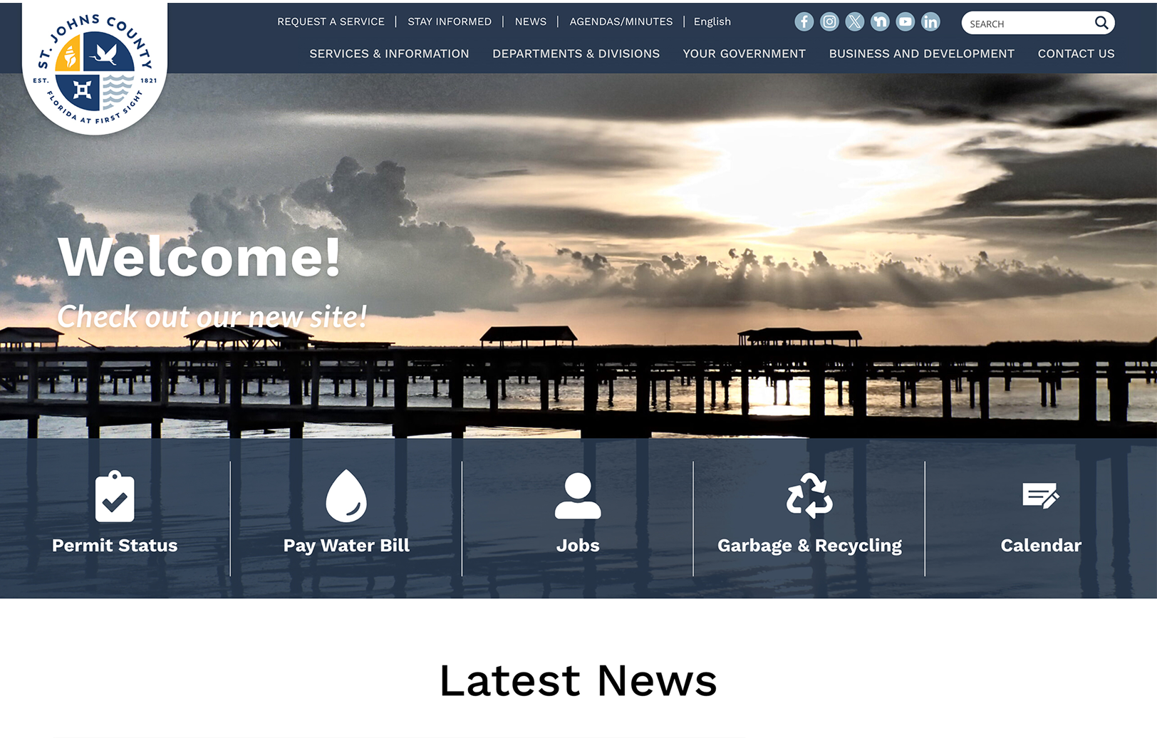 Screenshot of St. Johns County website homepage showing a pier at sunset, a welcome message, and menu icons for Permit Status, Pay Water Bill, Jobs, Garbage & Recycling, and Calendar.