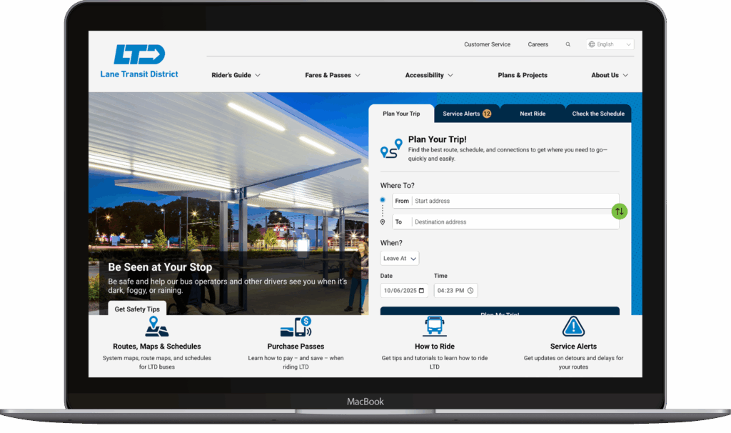 A laptop displays the Lane Transit District website featuring trip planning options, route information, and rider alerts against a background image of a transit stop at dusk.