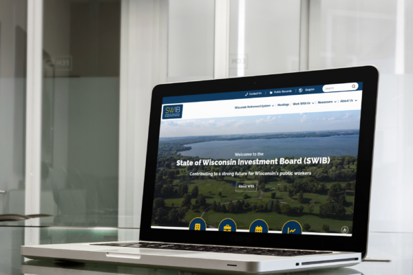 A laptop on a glass desk displays the homepage of the State of Wisconsin Investment Board (SWIB) website in a modern office setting.